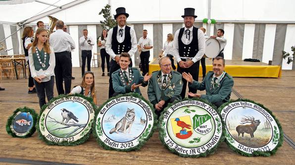 Lena Wolf, Alyssa Kobbelt, Jens Möller, Scheibenmaler Gerd Köpp und Reinhard Busche (vo.v.li.), dahinter mit Zylinder Scheibenträger Philip Köhler und Chris Rühmkorf (v.li.) - im Hintergrund die Kapelle "Scheibennagler" – Foto: E. Nowak